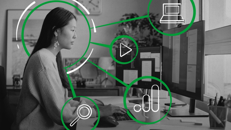 Woman at a computer, overlaid with green lines and icons for search, video, laptop, and data analytics.