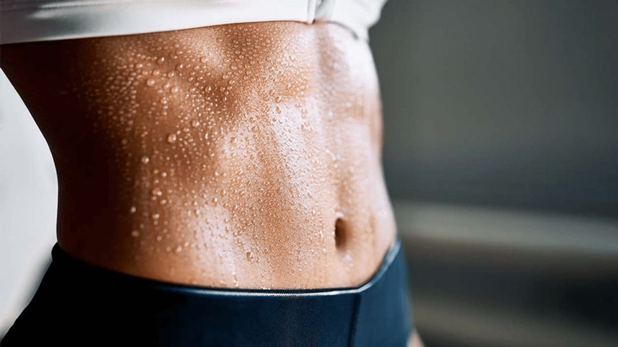A toned abdomen covered in sweat droplets.