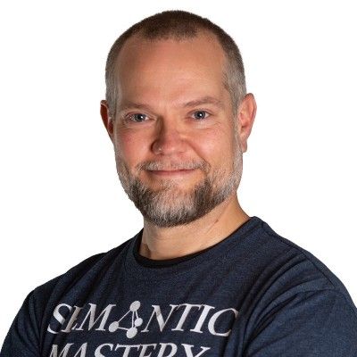 Smiling man with a beard wearing a "Semantic Mastery" t-shirt.
