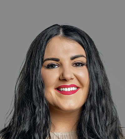 Headshot of a smiling woman with long dark hair and bright pink lipstick.