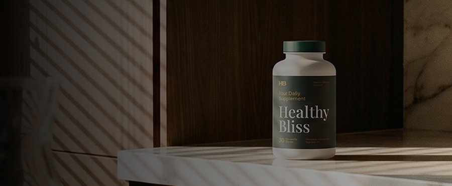 White bottle of "Healthy Bliss" daily supplement with a green cap, on a counter with striped shadows.