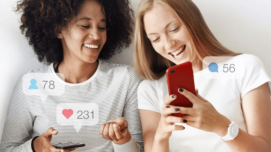 Two smiling women looking at phones with social media notification icons for likes, followers, and comments.