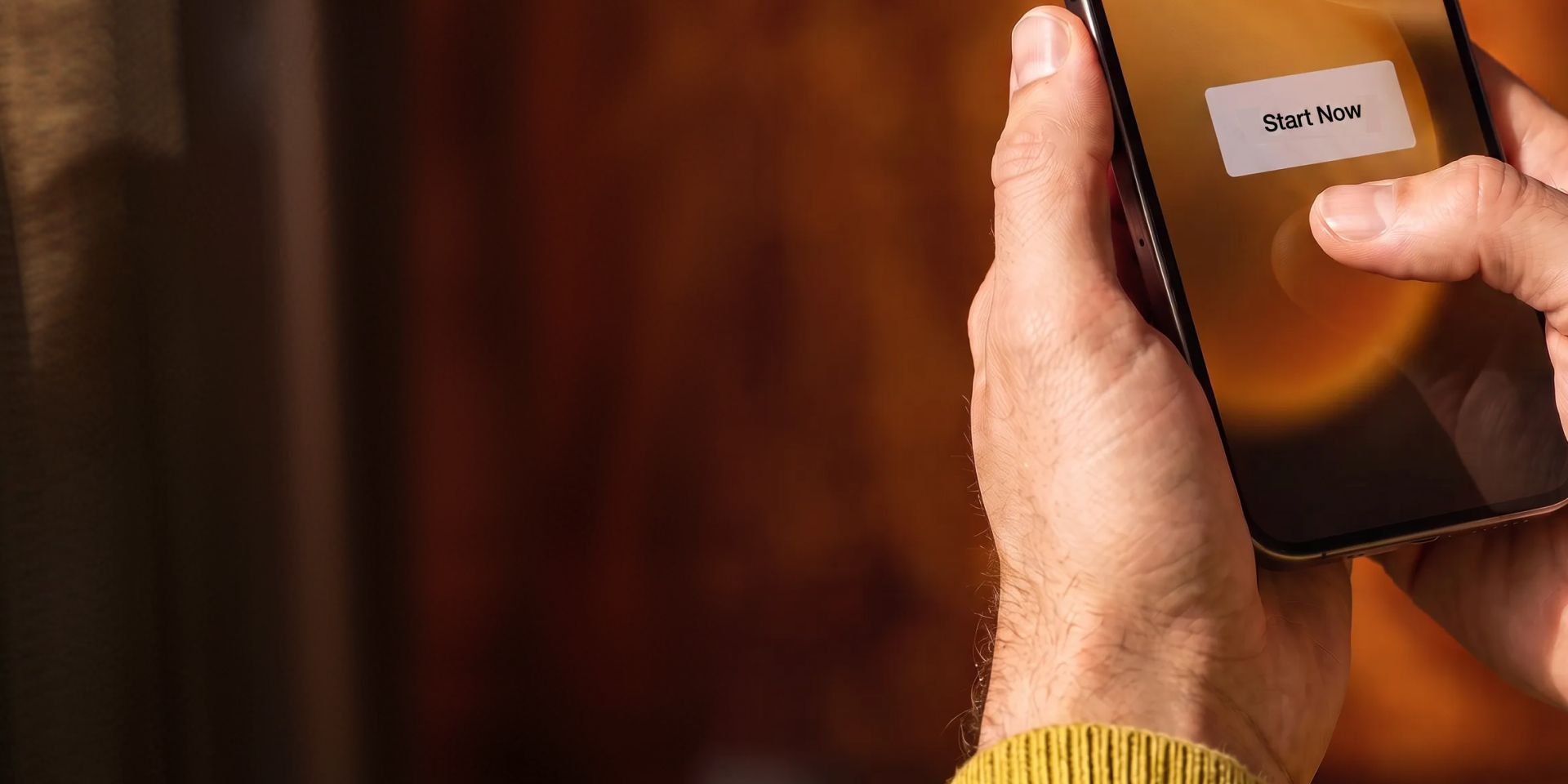 Hands tapping a "Start Now" button on a smartphone screen.