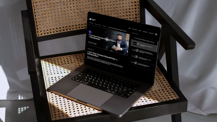 A laptop displaying an online course on a cane chair.