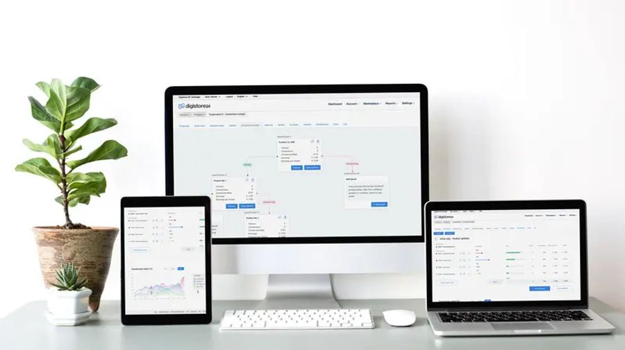 A desktop monitor, tablet, and laptop display a business application with data visualizations and flowcharts.