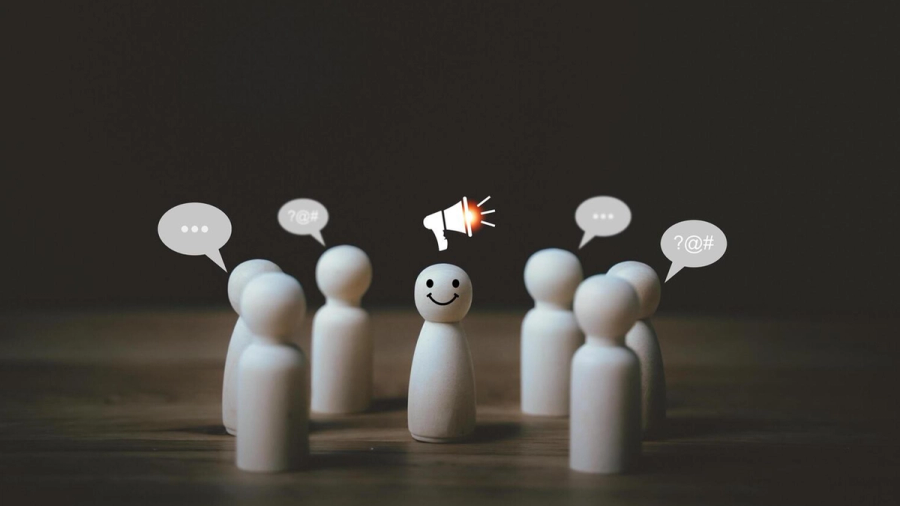 Smiley peg doll with a megaphone icon speaking to other peg dolls with speech bubbles.