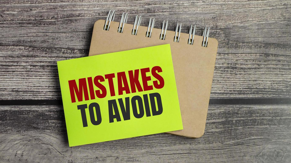 A yellow sticky note on a notebook reads "MISTAKES TO AVOID".