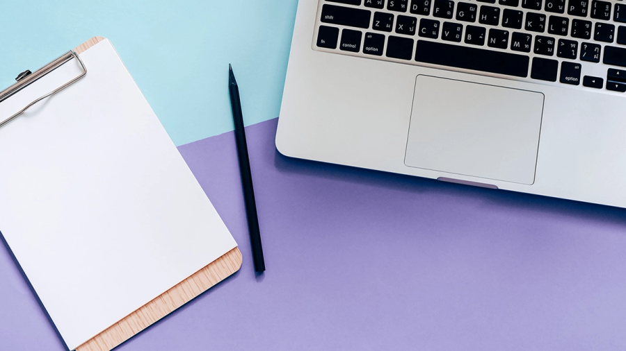 A clipboard with blank paper, a pen, and a laptop on a pastel blue and purple background.