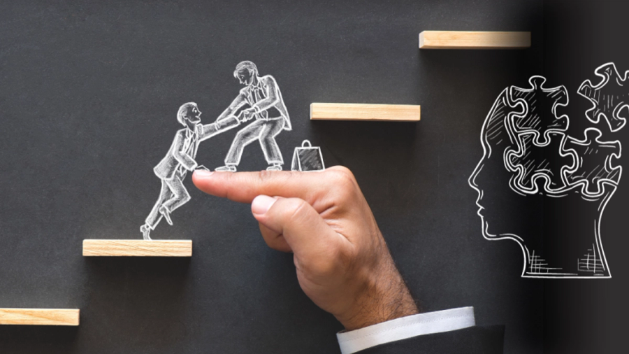 Chalk drawing on black: A hand supports two figures climbing wooden steps, one helping the other. To the right, a head silhouette filled with puzzle pieces, some floating away.
