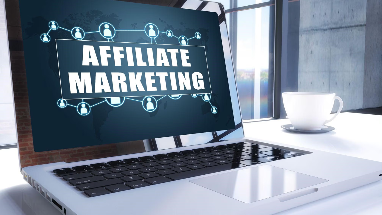 Laptop displaying "AFFILIATE MARKETING" with a network graphic, next to a coffee cup.