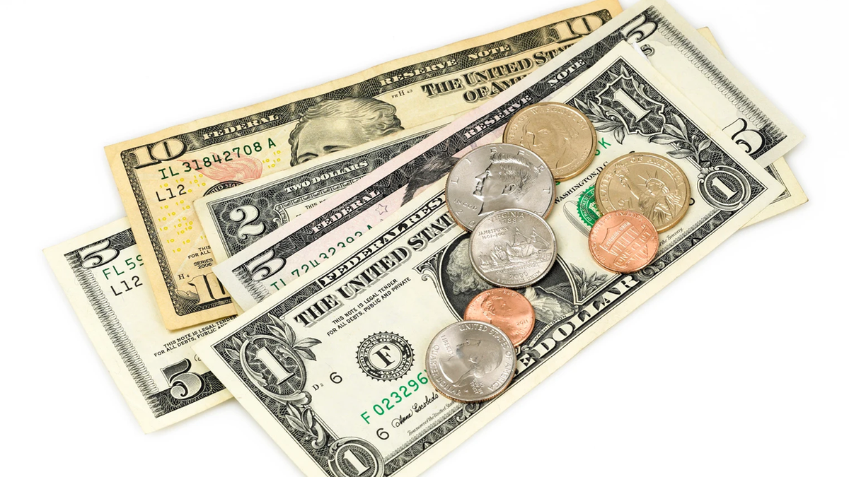 Assorted US dollar bills and coins on a white background.