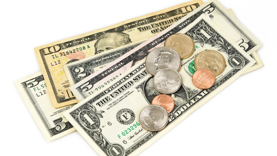 Assorted US dollar bills and coins on a white background.