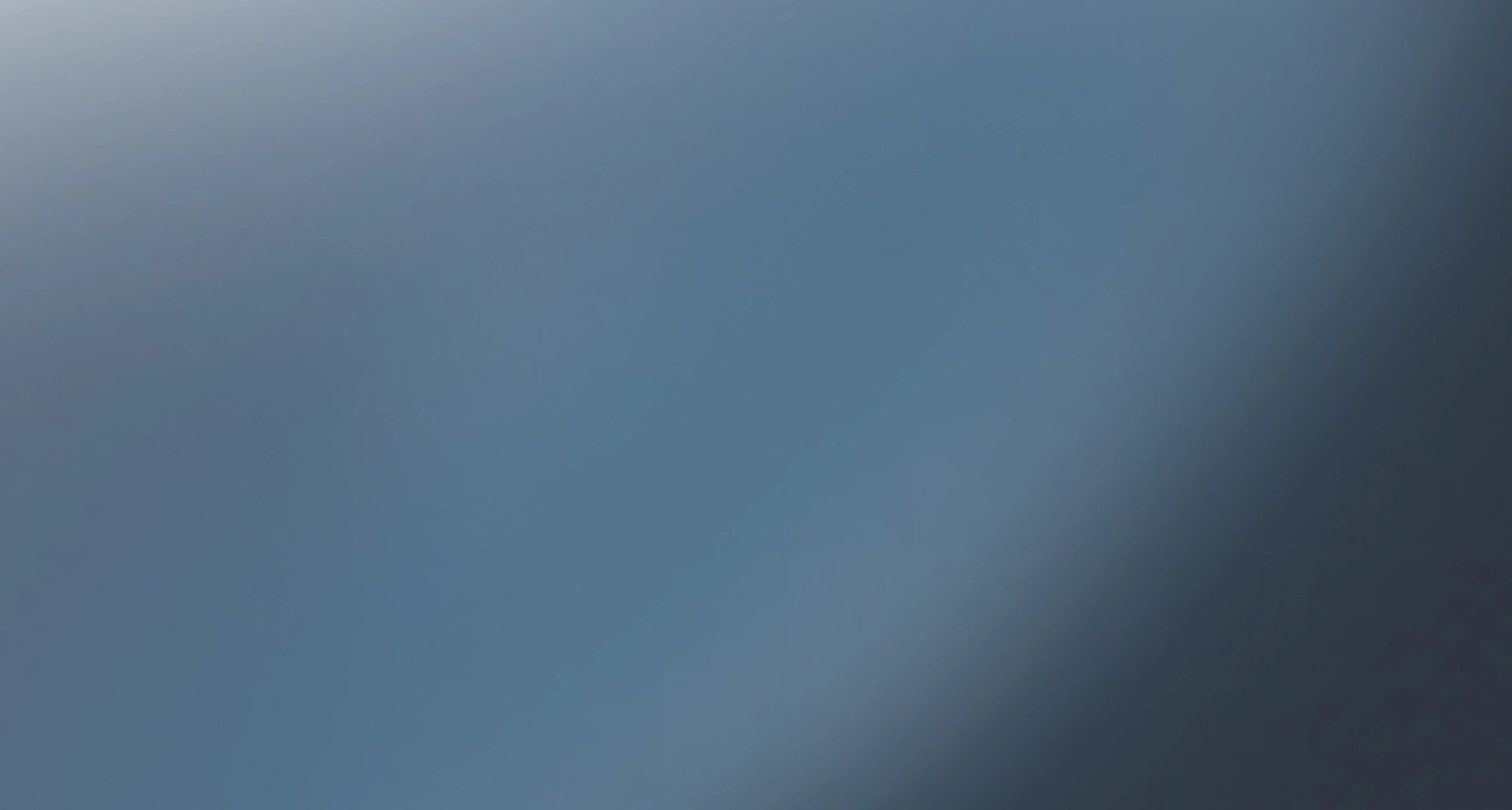 Abstract blurred blue-grey gradient background.