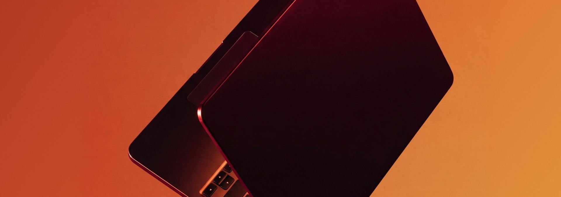 Red laptop on an orange surface.