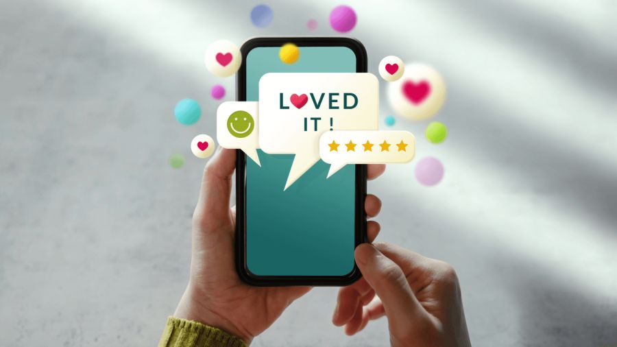 Hands holding a smartphone displaying positive feedback including "LOVED IT!", a smiley face, and five stars, surrounded by floating hearts and spheres.