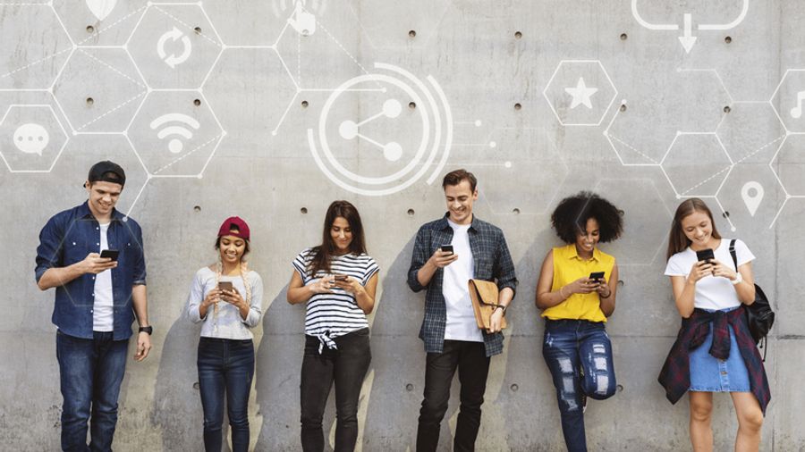 Six diverse young people absorbed in their smartphones against a wall with digital network icons.