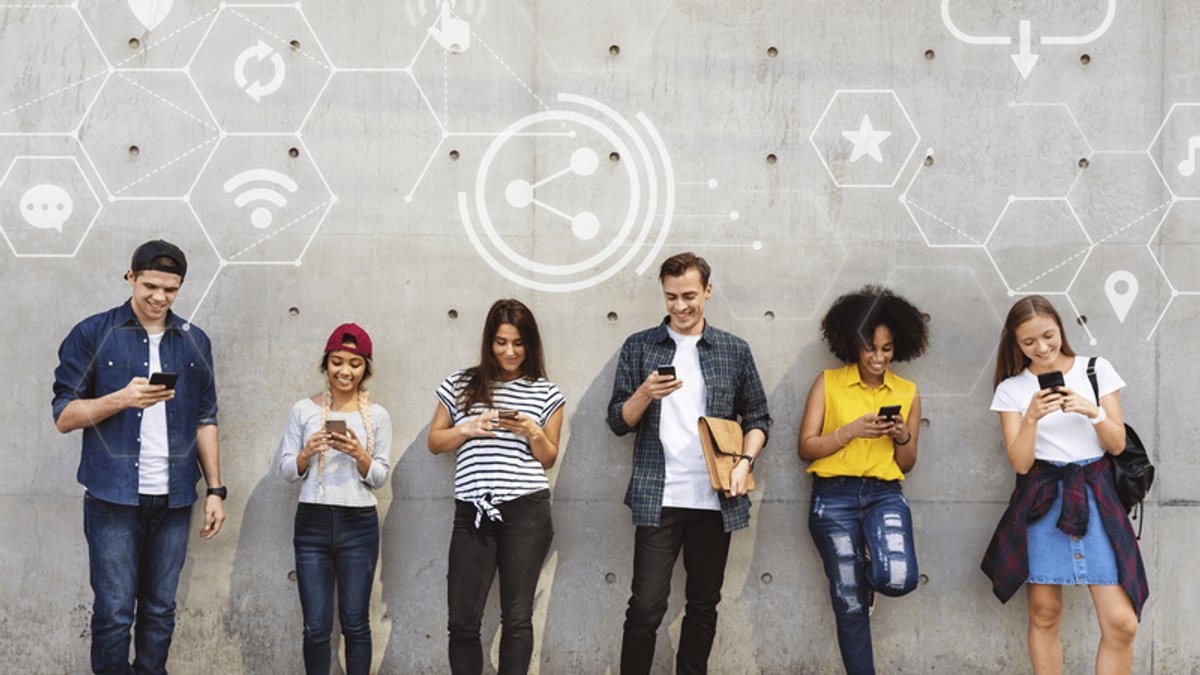 Six diverse young people absorbed in their smartphones against a wall with digital network icons.