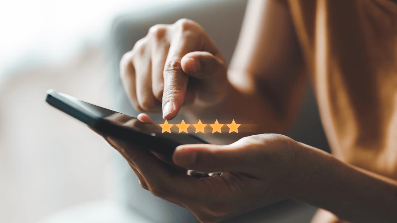 A person's hands giving a 5-star rating on a smartphone.