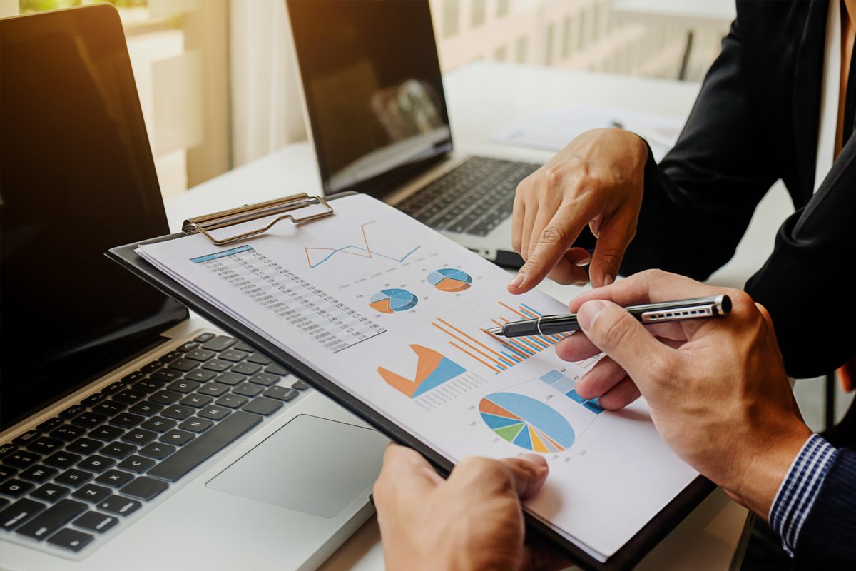 Two people analyzing business charts and graphs.
