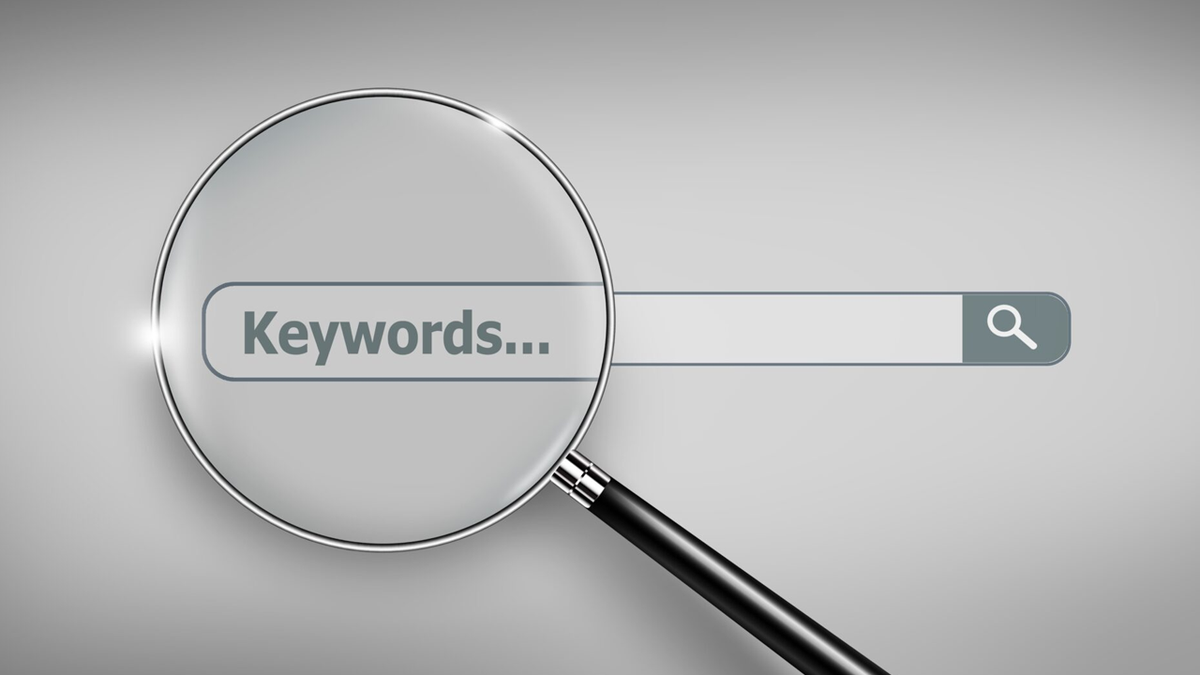 Magnifying glass over a search bar with "Keywords..." typed in it.