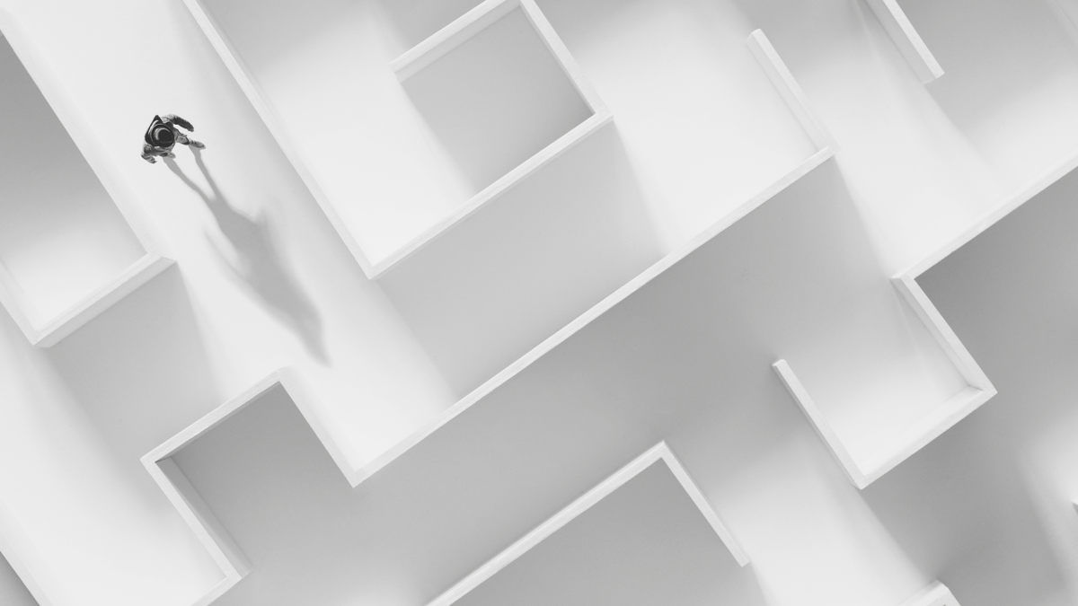 Top-down view of a person walking through a white maze.