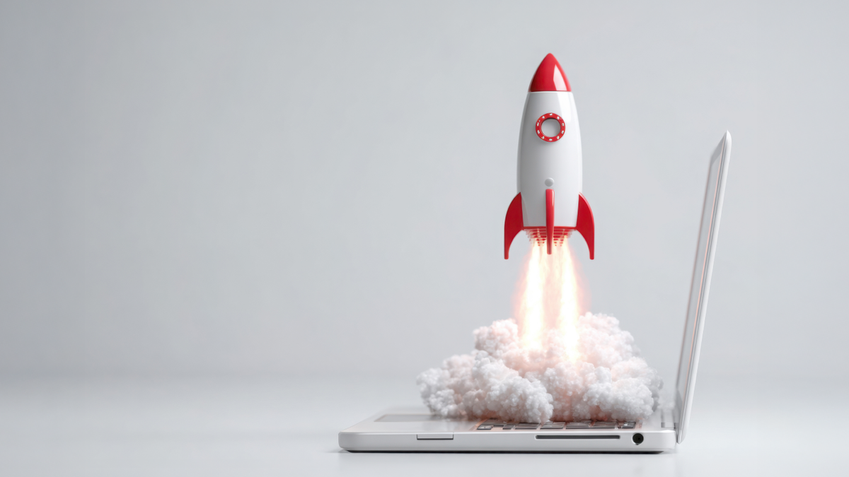 A white and red rocket launching with smoke and fire from a laptop keyboard.