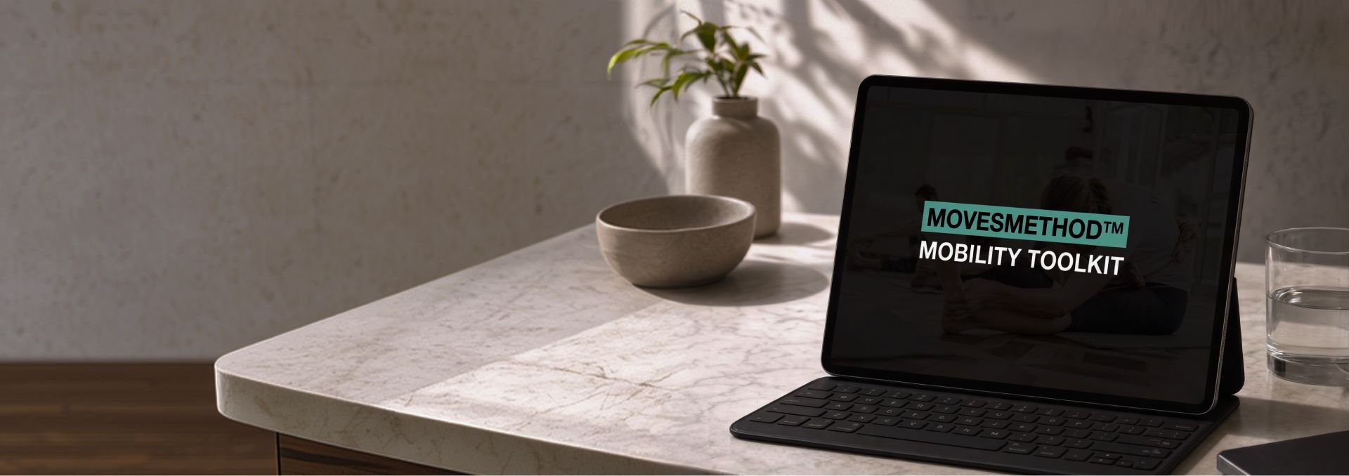 Tablet displaying "MOVESMETHOD™ MOBILITY TOOLKIT" on a light-colored table with a plant.