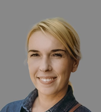 Smiling woman with blonde hair in a denim shirt.