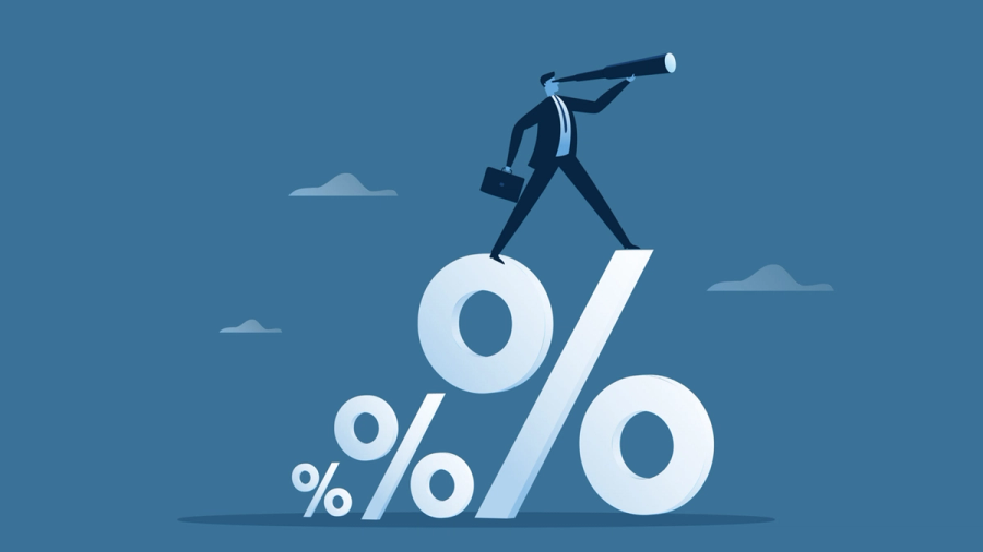 A businessman stands on a large percentage symbol, looking through a telescope.