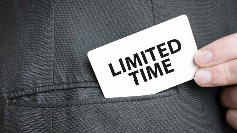 A hand pulls a white card with "LIMITED TIME" written on it from a suit pocket.