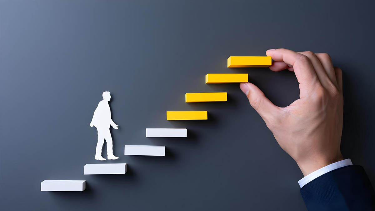 A white cutout person walks up block stairs while a hand places a yellow block as the next step.