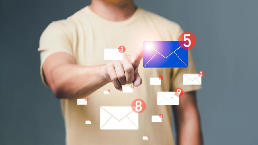 A person points at a glowing blue email icon with a '5' notification, surrounded by other floating email icons.