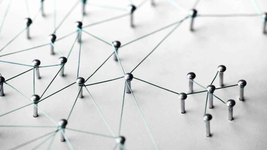 A network of silver thumbtacks connected by teal string.