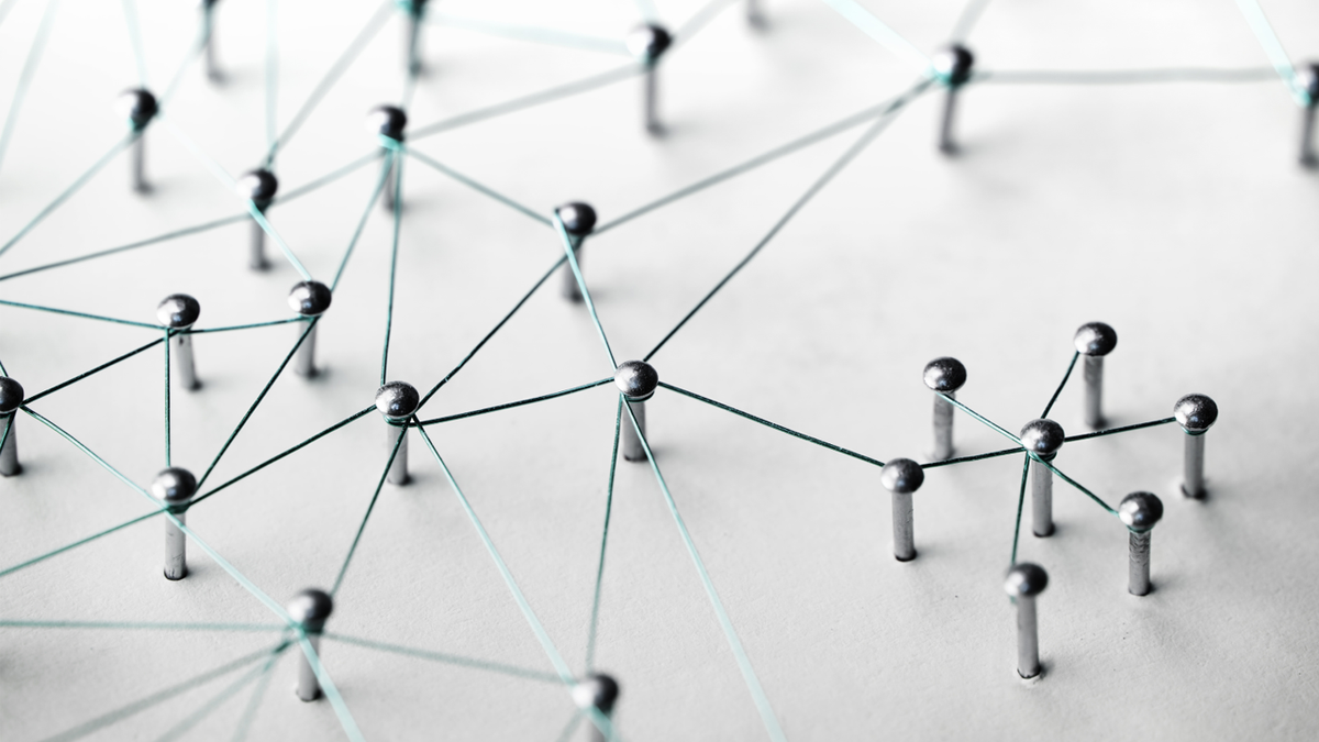 A network of silver thumbtacks connected by teal string.