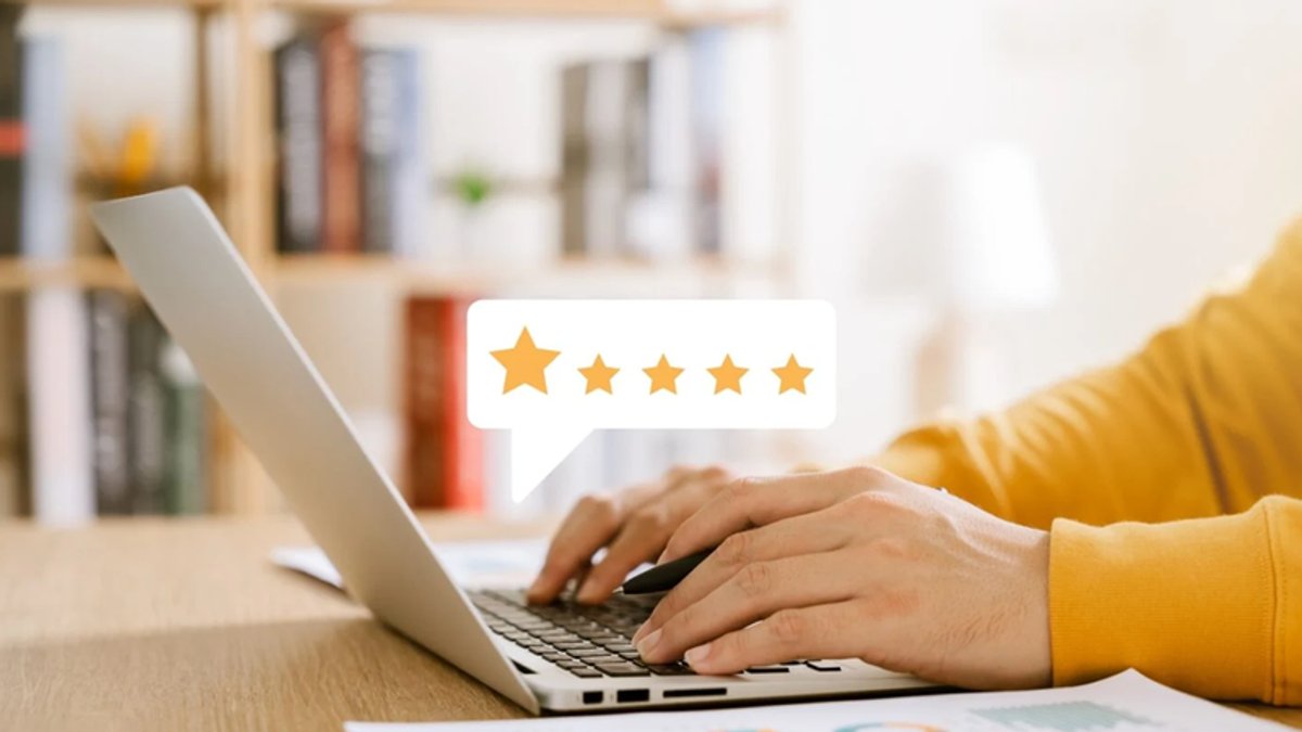 Hands typing on a laptop with a five-star review icon.