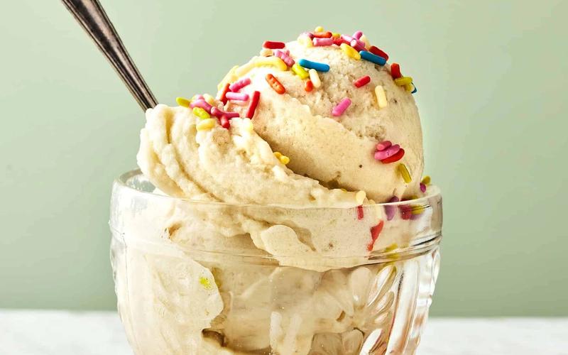 Frozen banana slices blended into smooth banana nice cream in a food processor, showing soft-serve texture