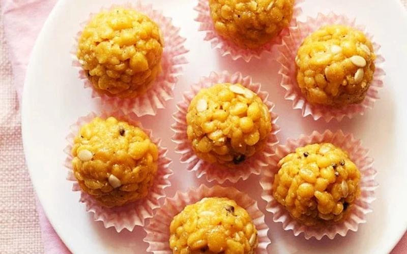 Step by step boondi ladoo recipe showing round boondi fried in oil draining on paper and being pressed into ladoo shape with oiled palms after sugar syrup soaking