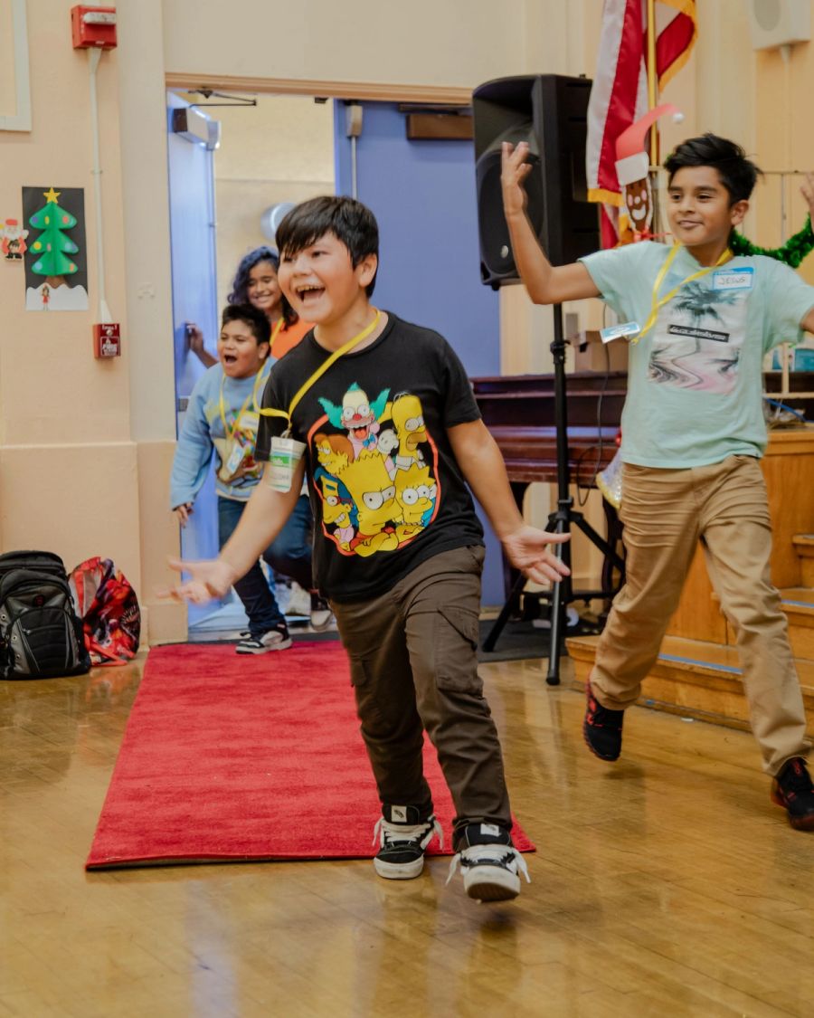 An excited boy running down a red carpet