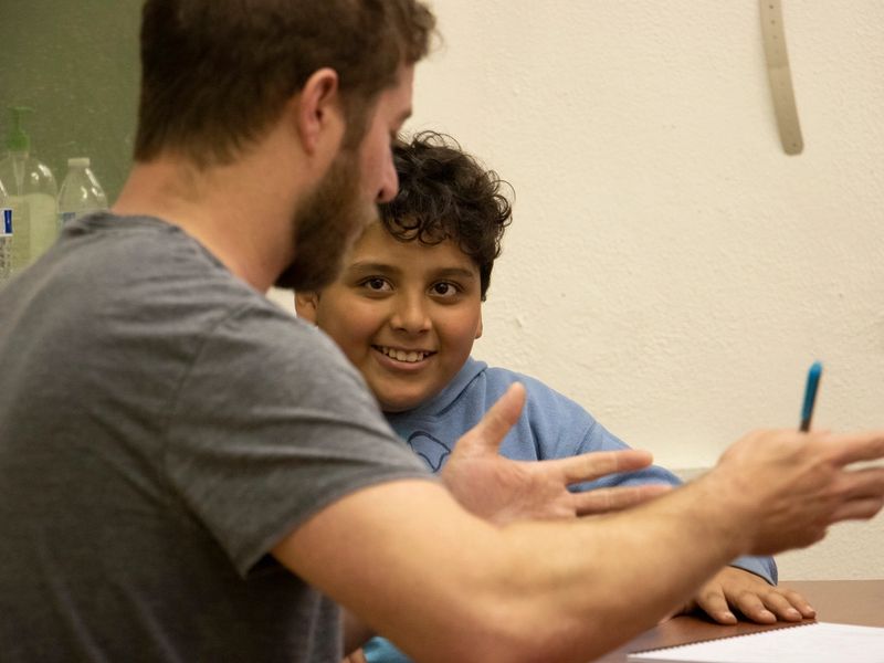 A boy looks at a man, smiling