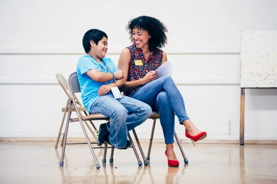 A mentor and student look at each other, smiling