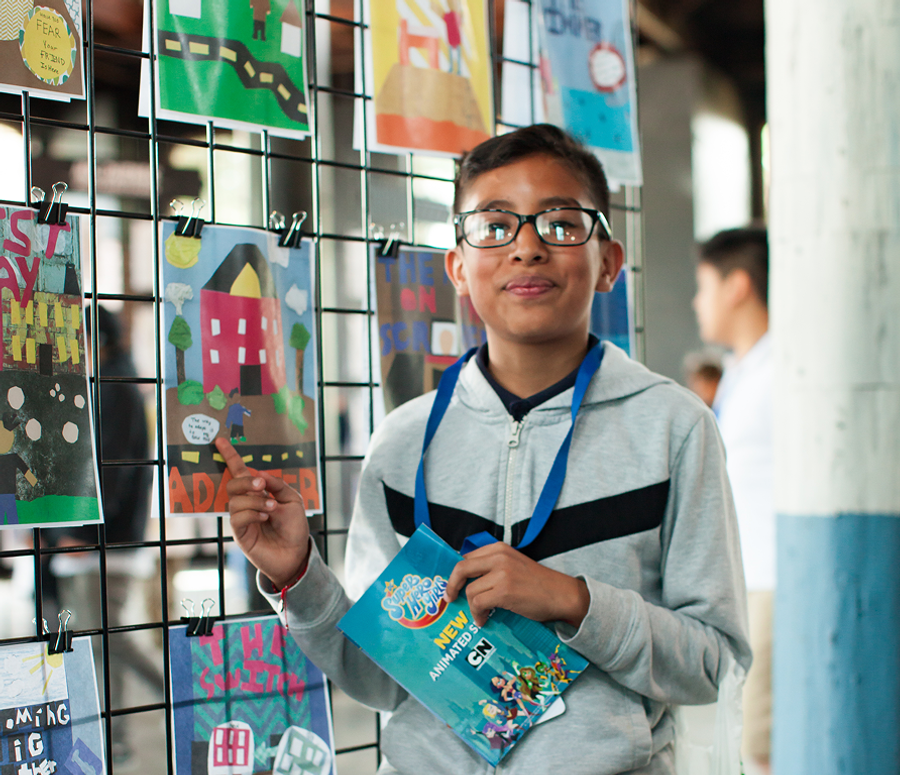 A student standing next to his story poster