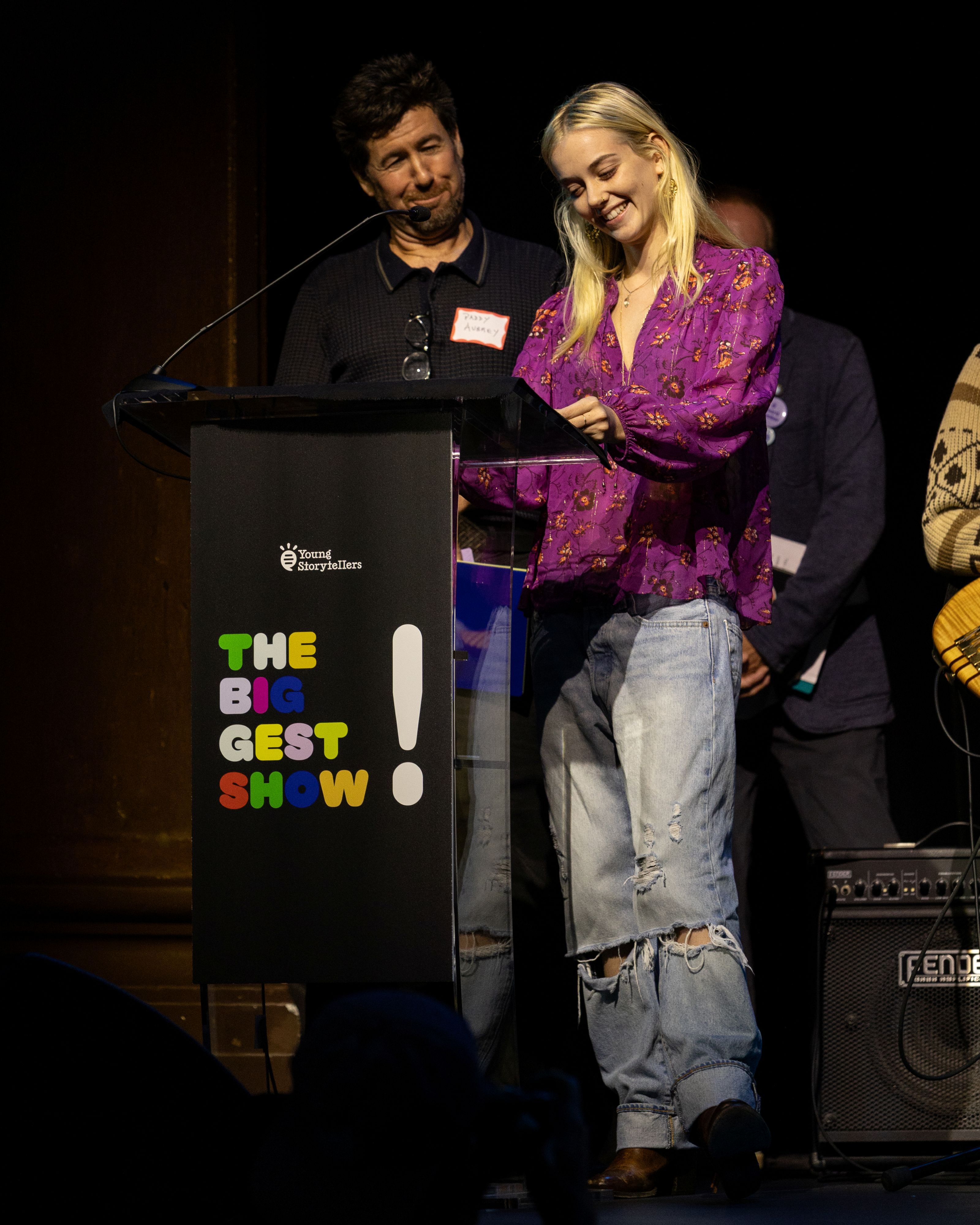  A man and a woman stand at a podium, smiling