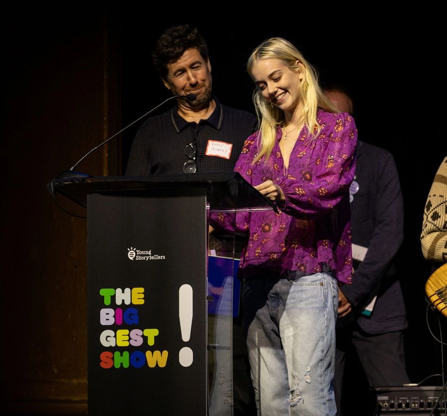 A man and a woman stand at a podium, smiling