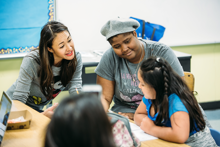Mentors and students collaborating around a table