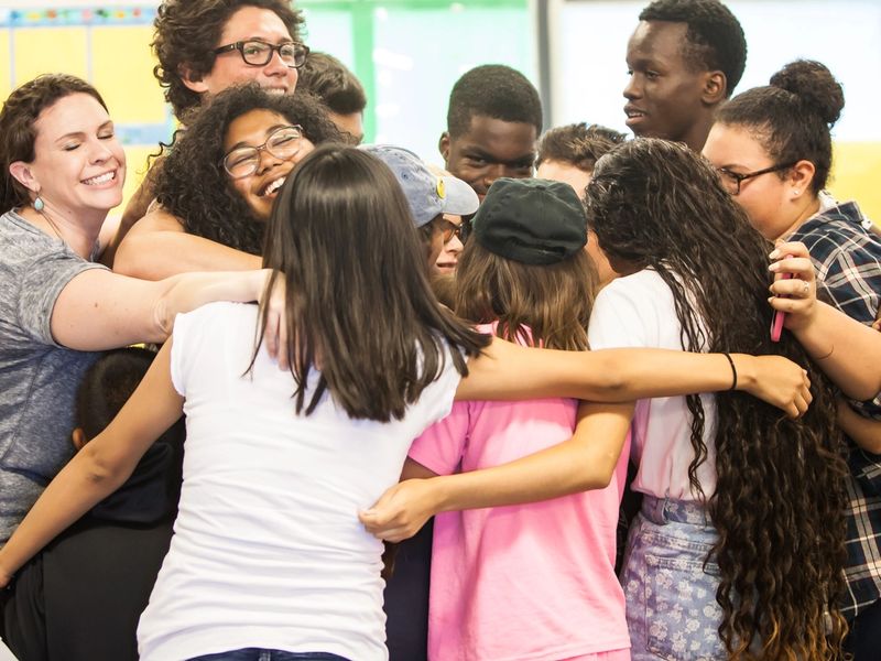 A group of volunteers and students hugging