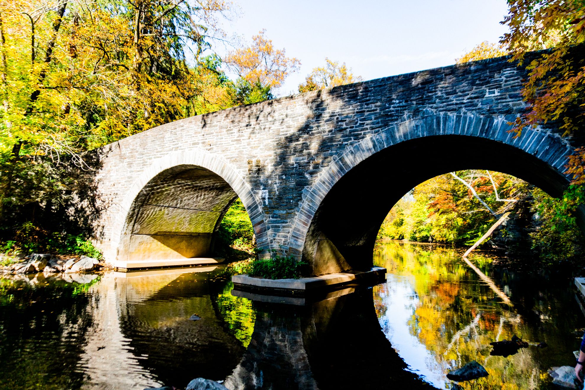 A view of an aqueduct footbridge as seen from the banks of the Wissahickon Creek.