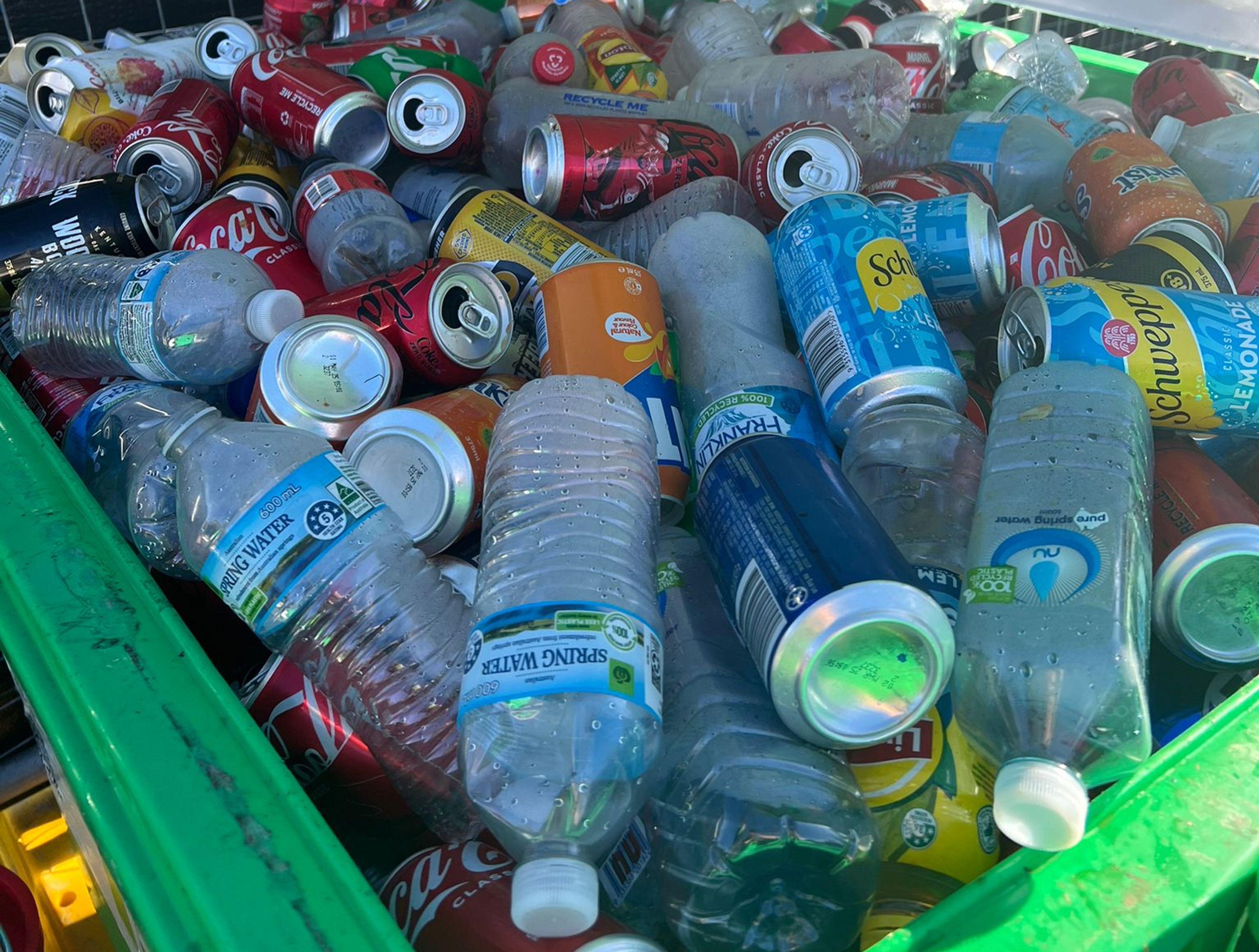 Empty plastic bottles and aluminium cans in recyclable bin