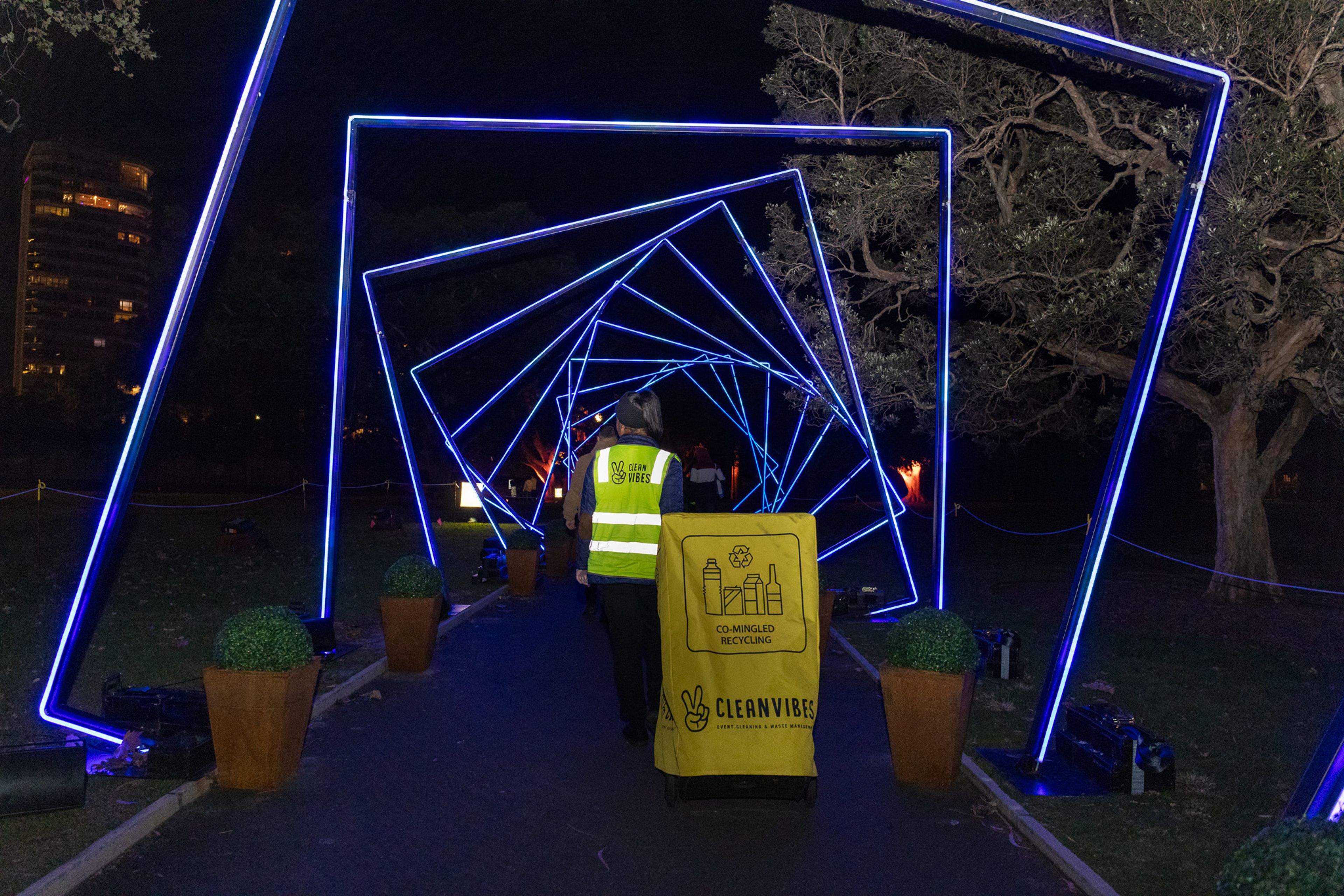 Clean Vibes employee wheeling a bin across the event 