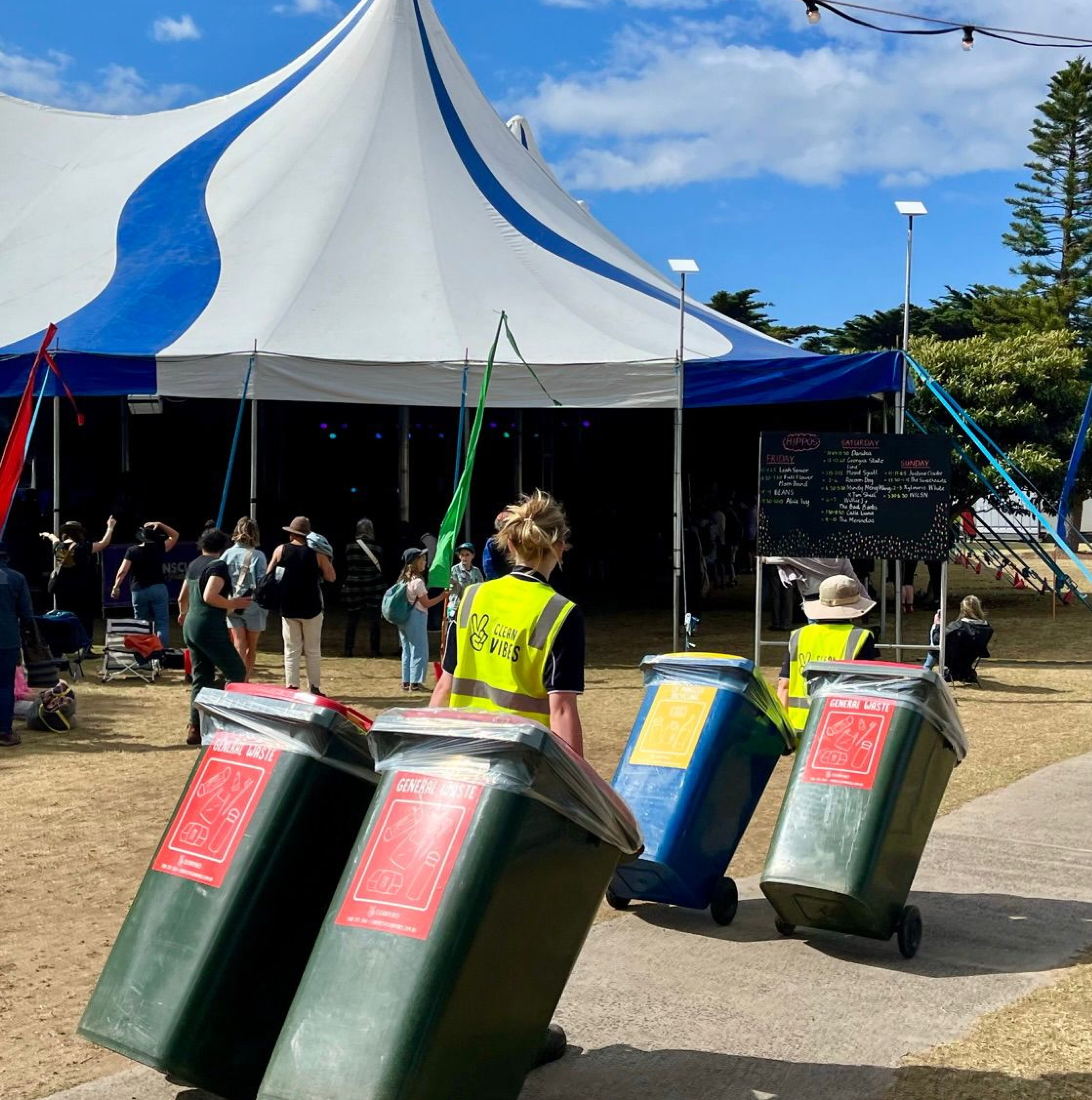 Clean Vibes employees wheeling bins  around the event
