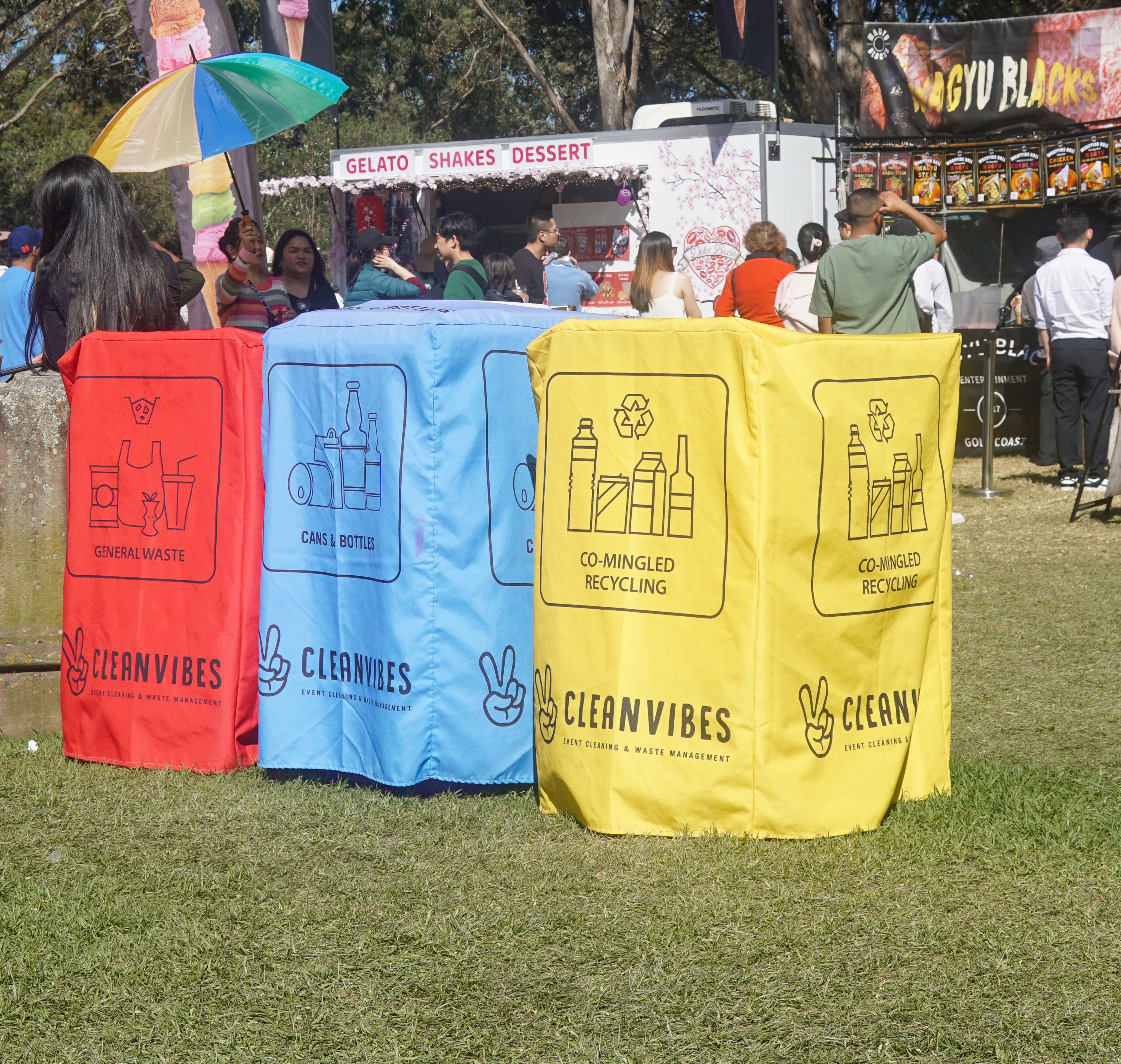 Clean Vibes red, blue and yellow bin covers displayed at food court location